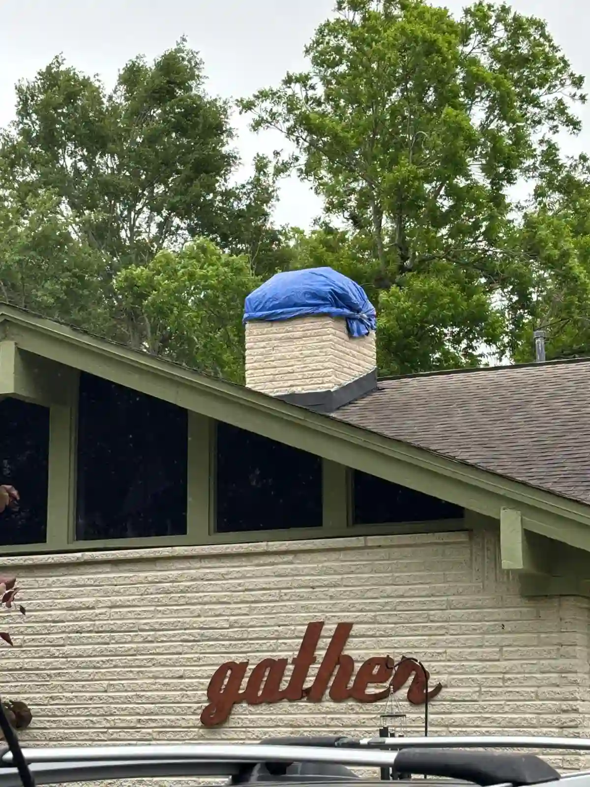 Texas Chimney LLC protecting a damaged chimney with a blue tarp before waterproofing in Houston.