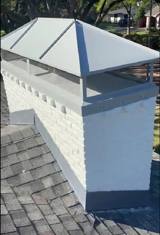 Completed chimney cap installation with a gray metal top and mesh screen by Texas Chimney LLC.