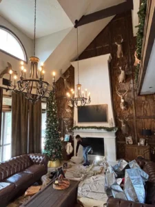 A person is actively involved in the decorating process, specifically working near a large fireplace mantel.