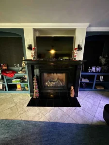 a living room featuring a fireplace with a black surround and mantel.