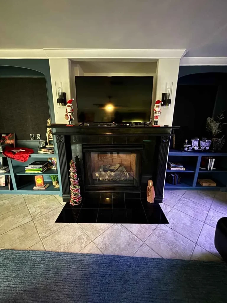a living room featuring a fireplace with a black surround and mantel.
