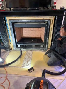 a person installing or servicing a fireplace insert, which is a self-contained appliance designed to fit into an existing masonry fireplace.